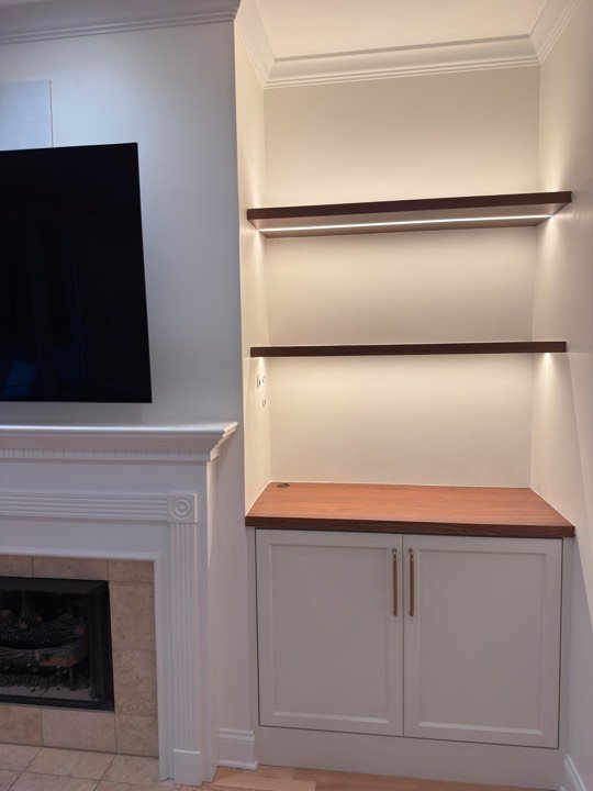 Built-in shelving and cabinets flanking a fireplace.
