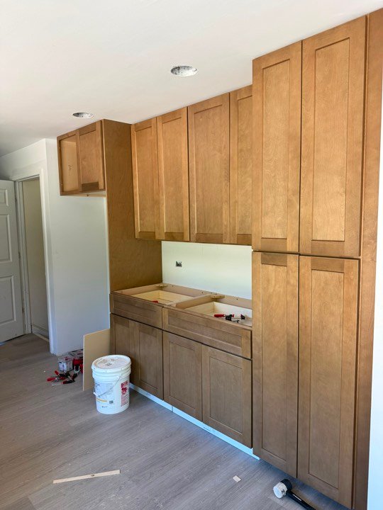 Stained wood cabinetry part-way through installation.