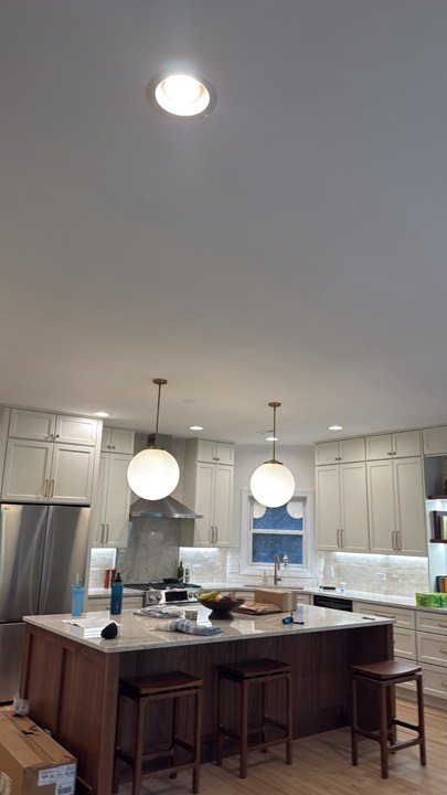 Kitchen island with globe pendant lights and white cabinetry.