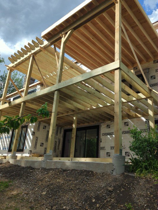 Pergola rafters and beams part-way through framing.