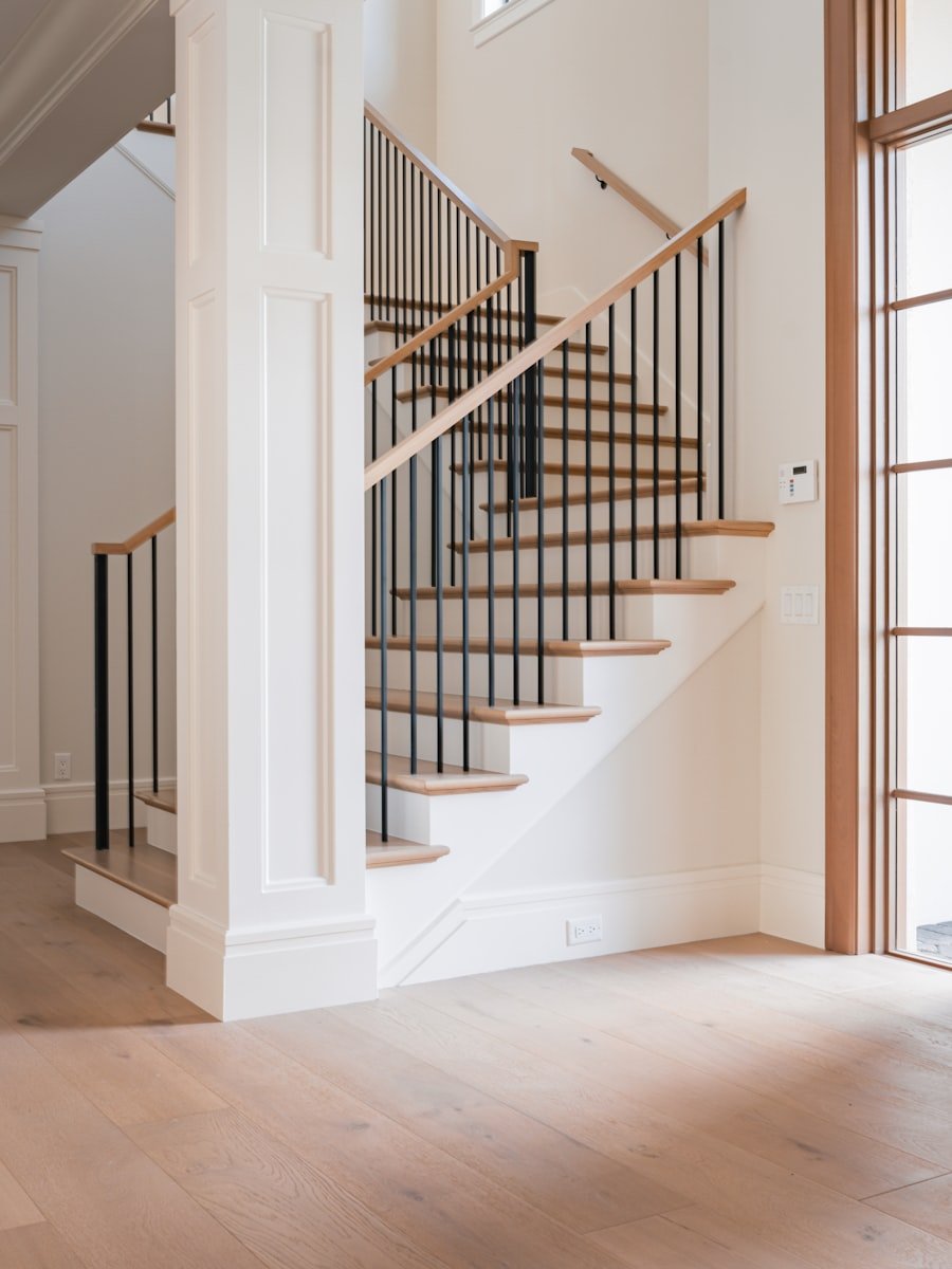 A staircase and hardwood flooring in a bright interior.